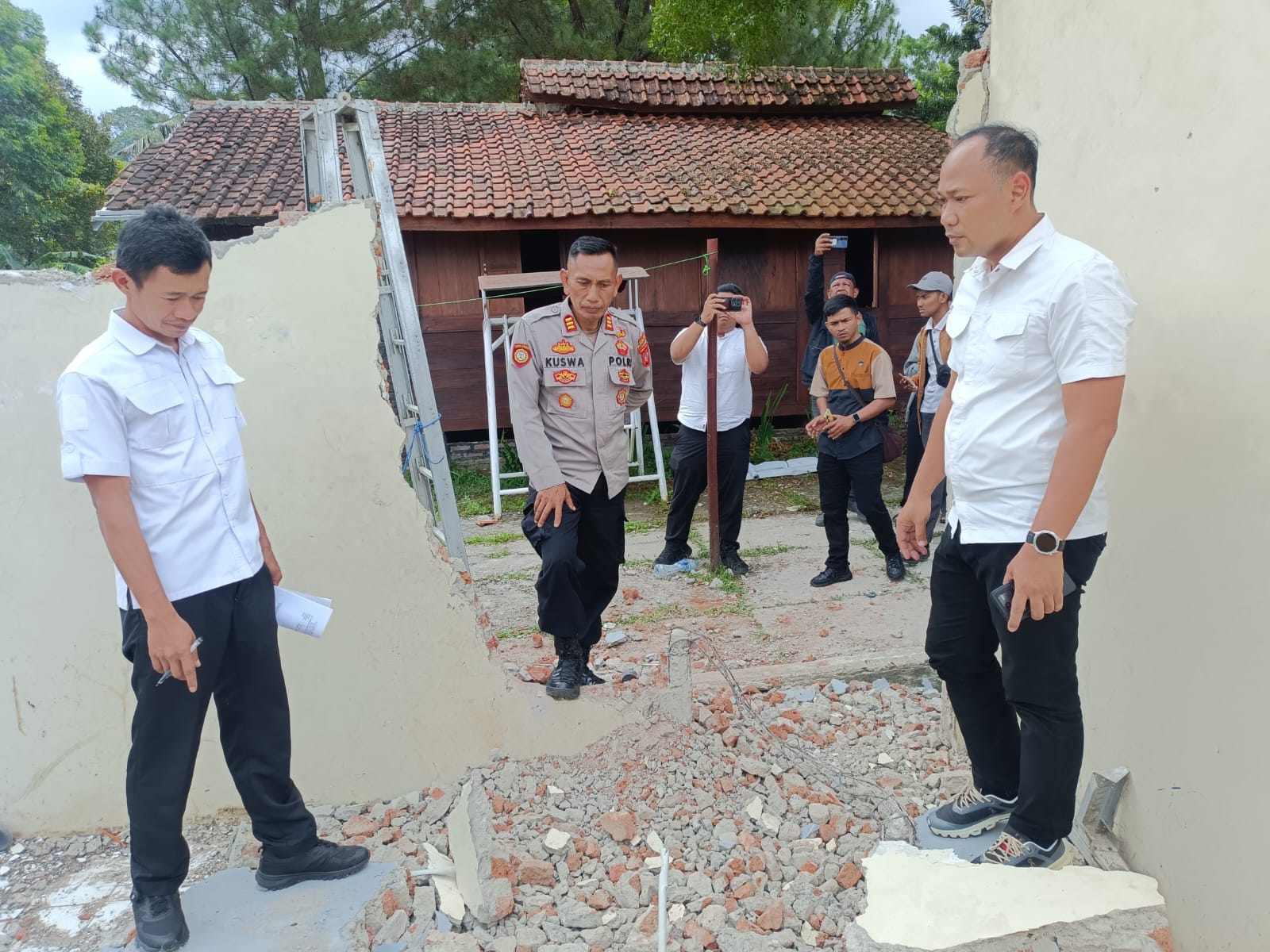 Kapolsek Cigugur, AIPTU Kuswa, SE saat meninjau kejadian tembok roboh. (Foto: dok. ist/k1)