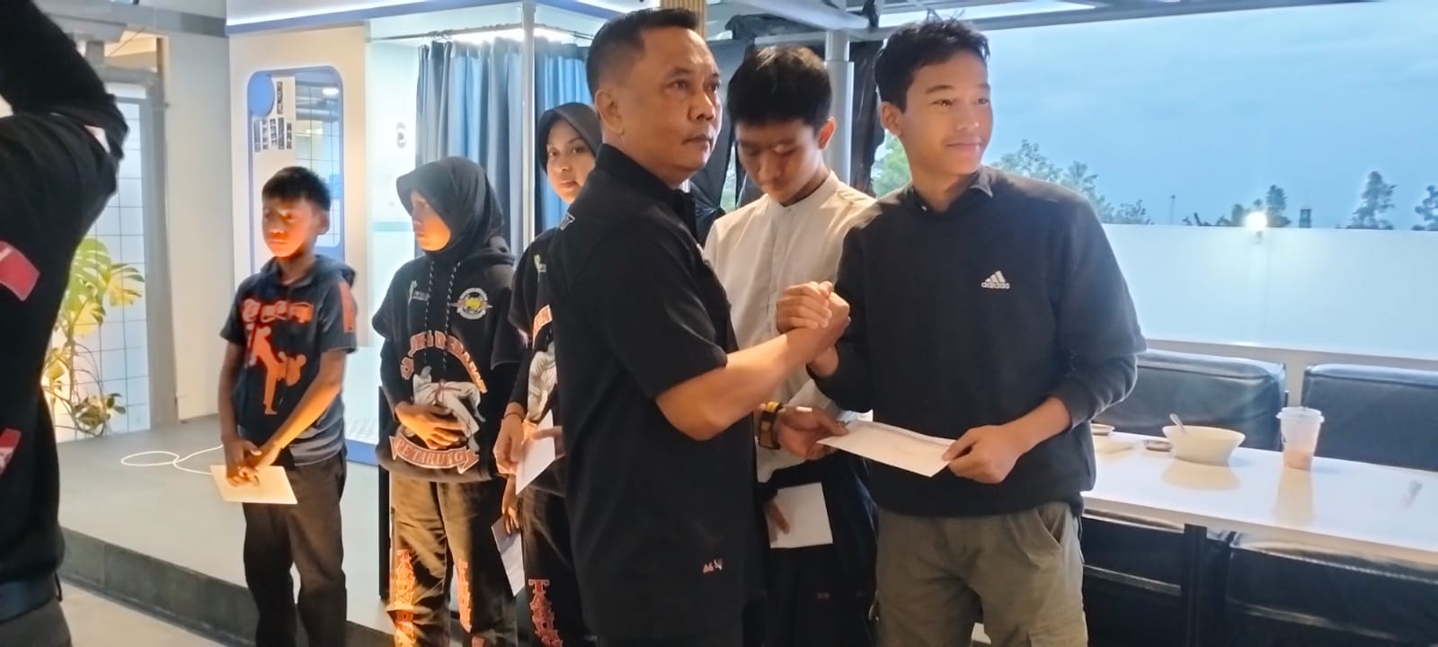 Ketua Pengcab Tarung Derajat Kabupaten Kuningan, Agus, SH., MH saat memberikan uang kadeudeuh kepada atlet peraih medali dalam ajang POPDA. (Foto: dok. ist/k1)
