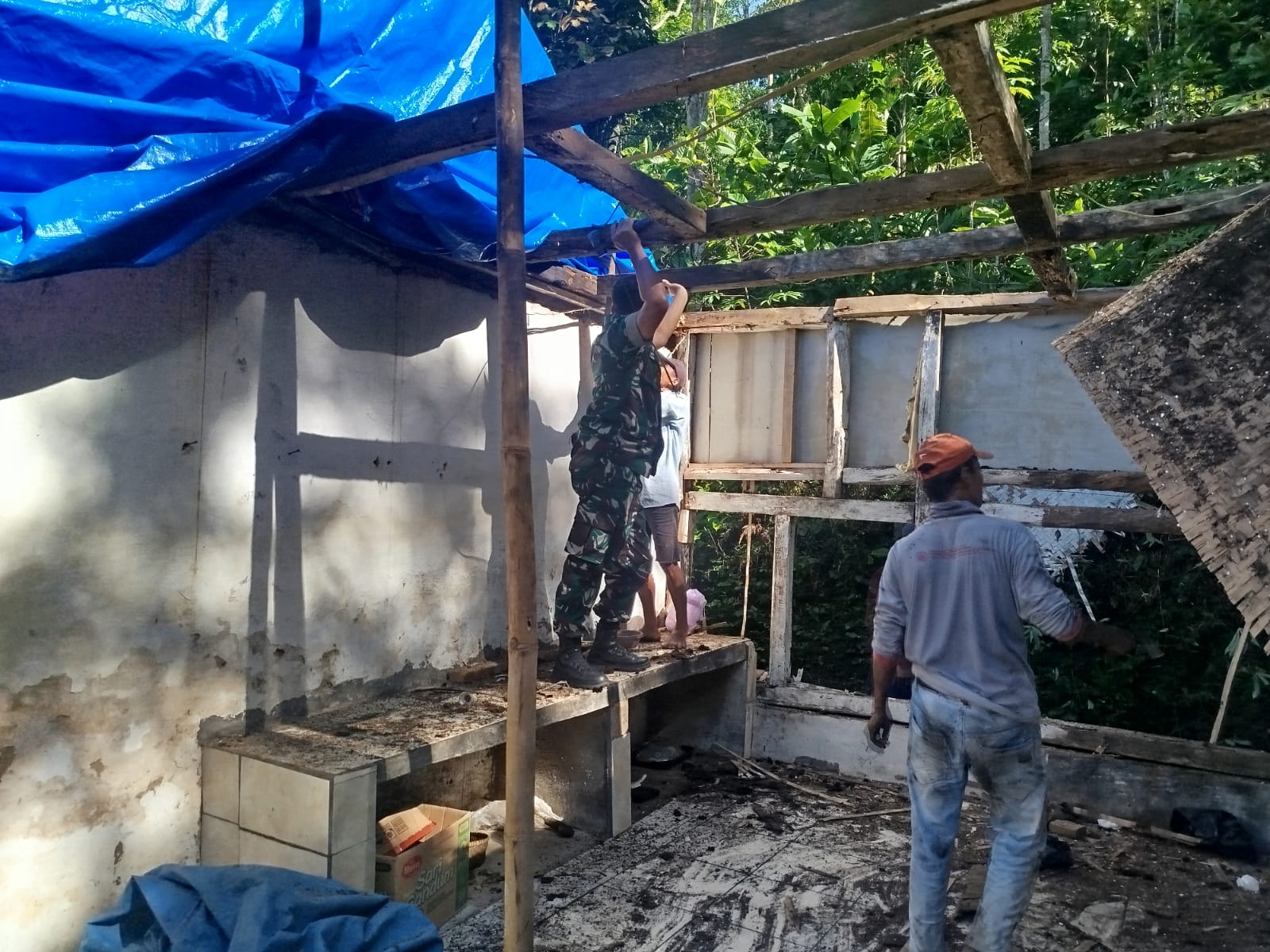 Babinsa Koramil 1504/Sbg membantu warga membersihkan rumah ambruk di Desa Cantilan (foto: dok. babinsa/tohirin)