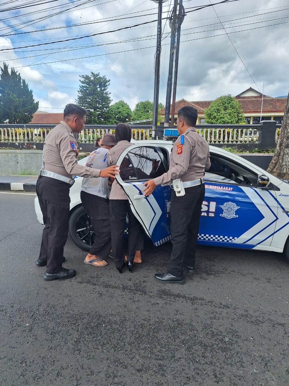 Polisi membantu mengevakuasi pengendara motor yang pingsan di Jalan Cigadung-Kuningan (foto: dok. polreskng/tohirin)