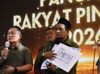 Bupati Kuningan Dian Rachmat Yanuar menyerahkan hadiah umrah kepada Daskim, Marbot Pinunjul 2026, dalam ajang Pangajen Rakyat Pinunjul 2026. (Dok. Humas)